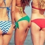 close up of happy young women on beach from back