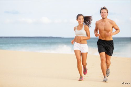 Young couple running on beach. Man enjoying run with no shirt on after male breast reduction-img-blog