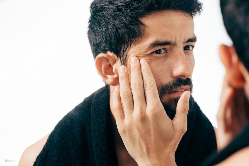 Man in front of mirror looking at his wrinkles