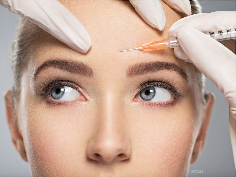 Young woman preparing for an injectable treatment in her forehead. 