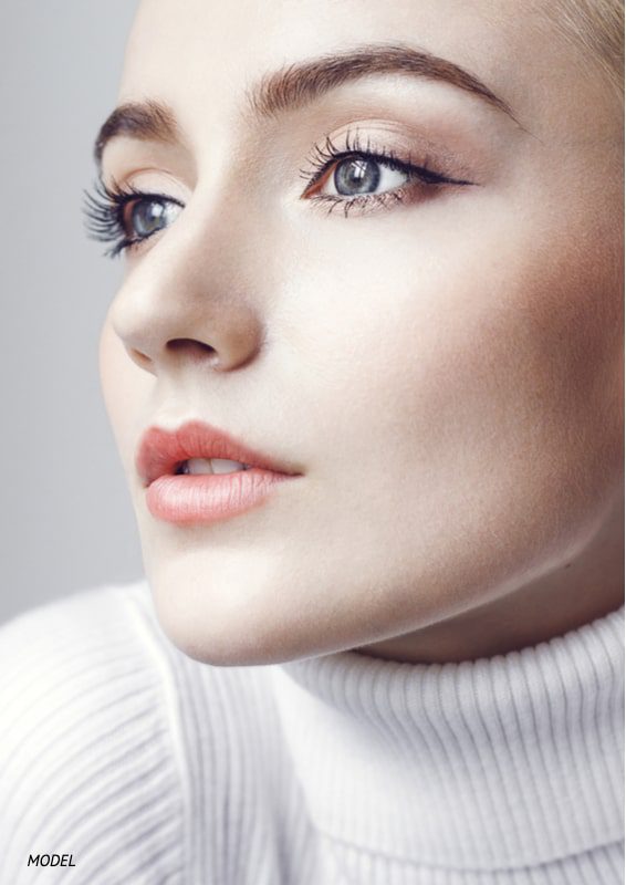 Close-up image of a woman's face showing a three-quarter profile of her nose.