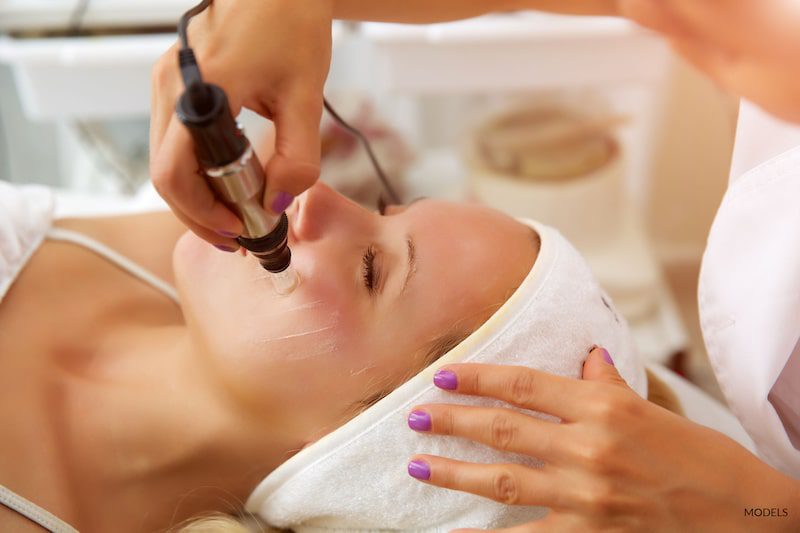 Woman is receiving microneedling treatment.