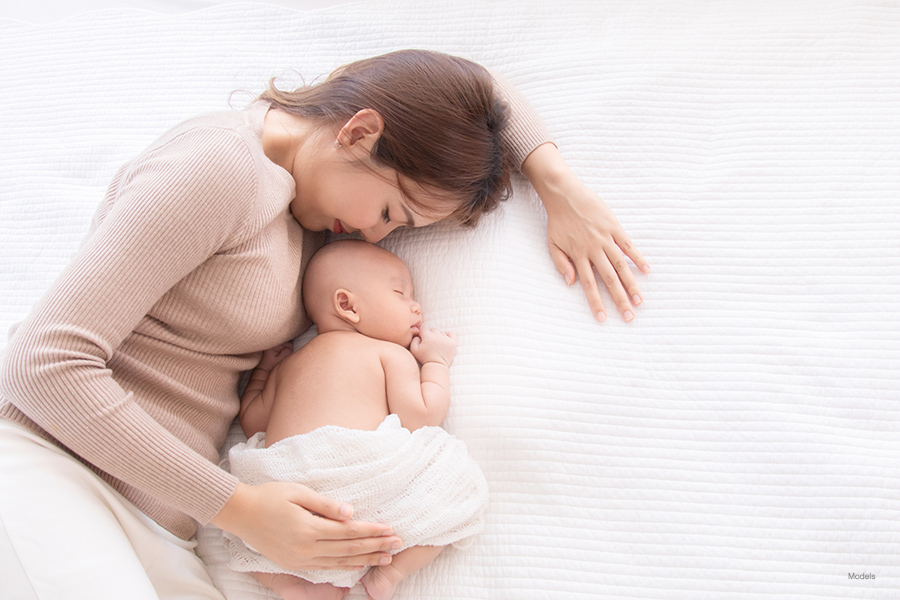 Woman and child laying on a bed