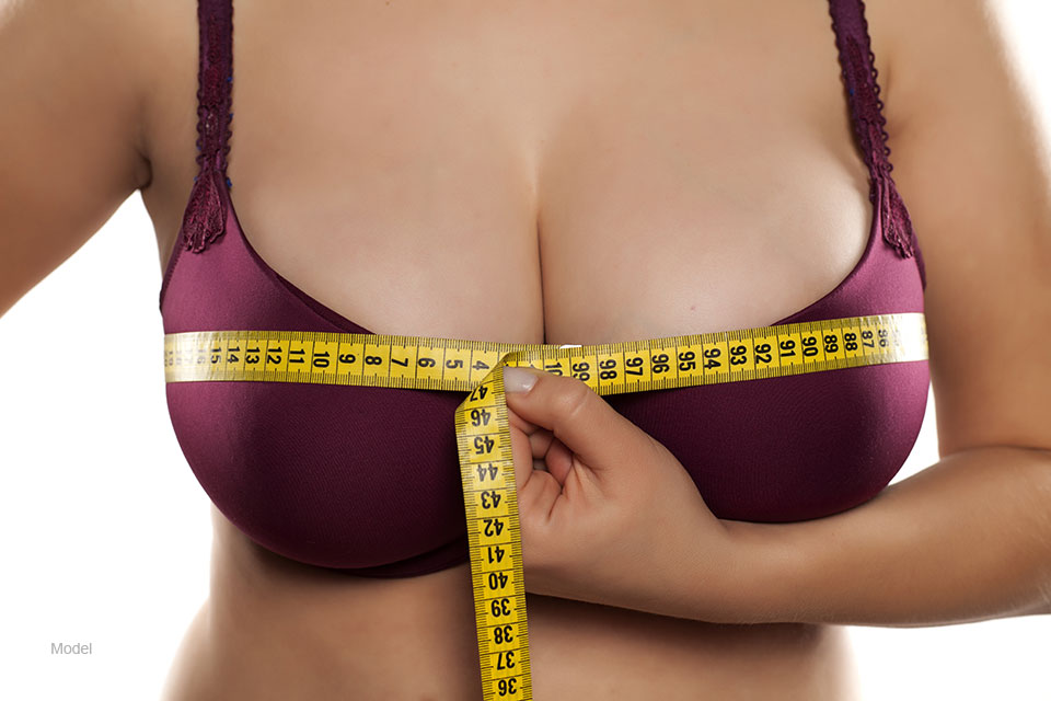 Woman measuring her large natural breasts