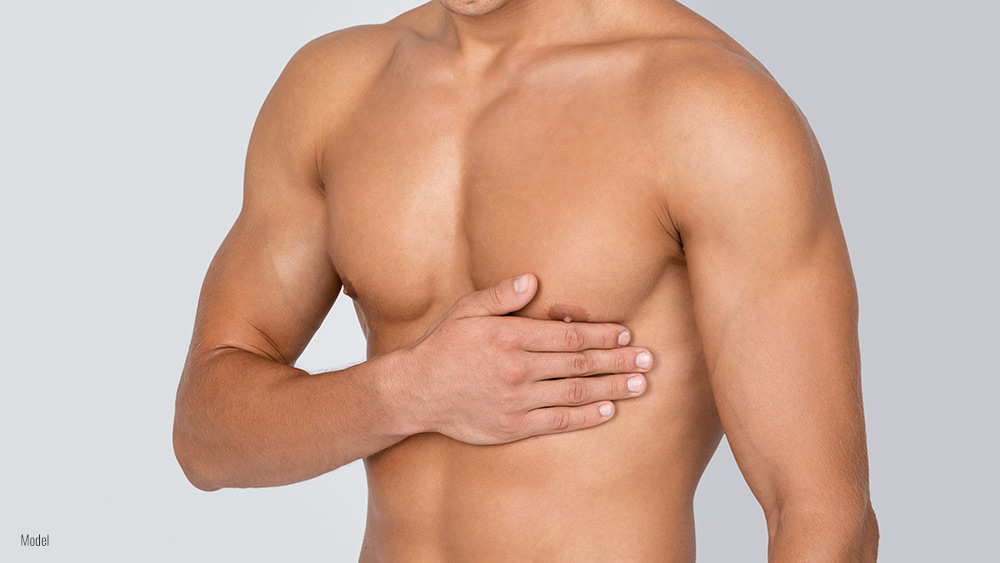 athletic male body with a hand to his chest