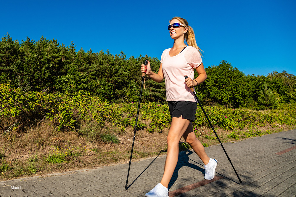 Fit woman walking with hiking poles