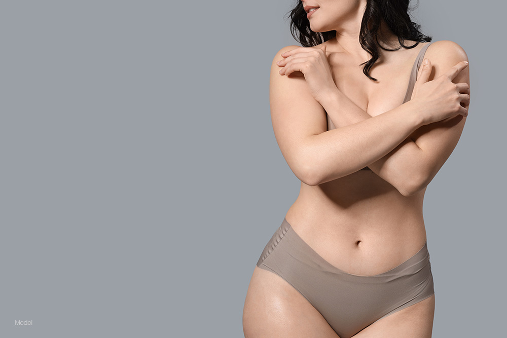 Curvy woman in tan underwear with her arms across her chest
