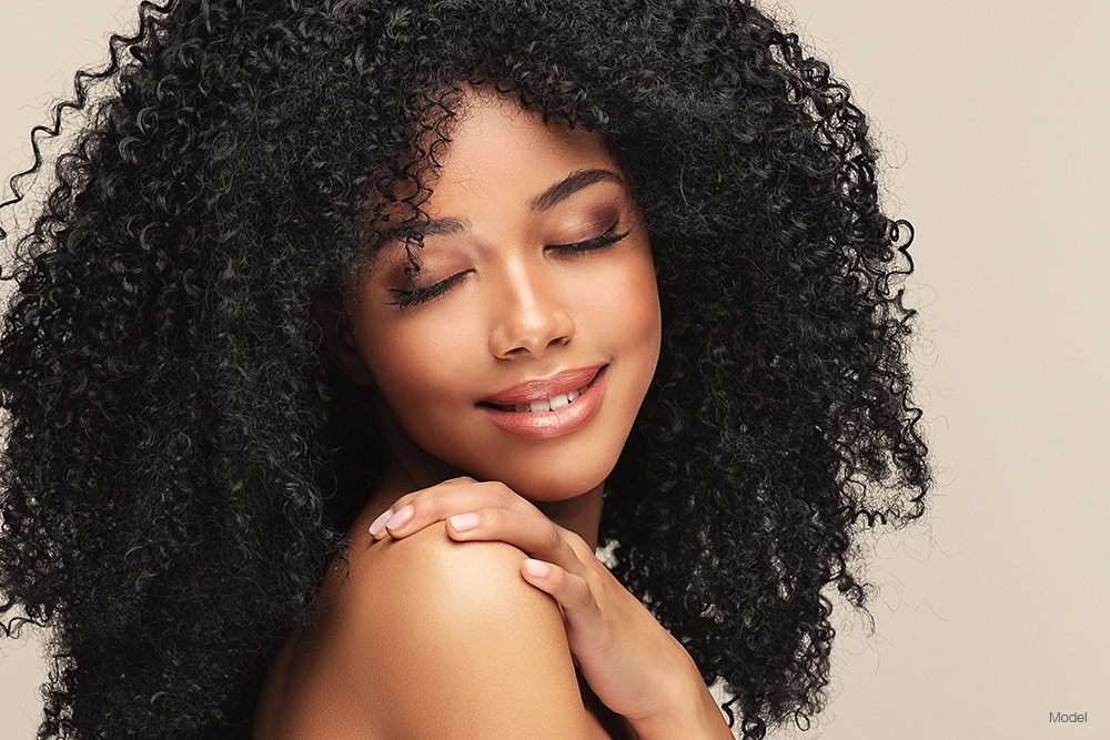 Ethnic woman with curly hair touching her shoulder